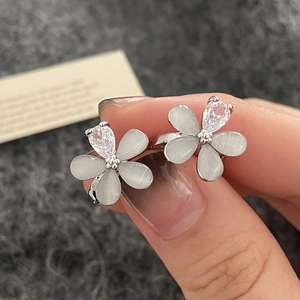 Gros plan de boucles d'oreilles fleur en pierre œil de chat et goutte de zircon