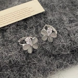 Gros plan de boucles d'oreilles fleurs en oeil de chat et zircon sur tricot foncé