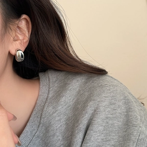 Minimalist silver teardrop earrings with high-polish finish on a model for daily wear