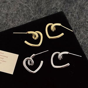 Minimalist twisted heart earrings in gold and silver finish with high polish shine