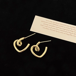 Macro shot of S925 sterling silver stamp on golden heart-shaped minimalist earrings