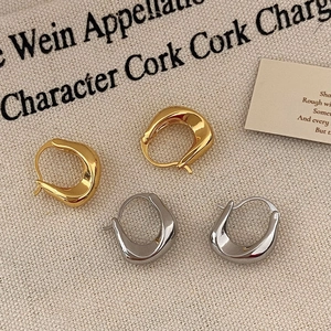 Minimalist twisted chunky hoop earrings in gold and silver finish with high polished surface