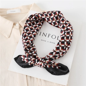 Detail of silk-like neckerchief with geometric plaid pattern knotted on a beige shirt