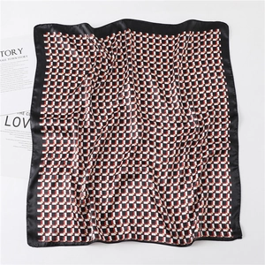 Detail of satin square scarf with geometric plaid pattern and black border trim