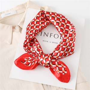 Close-up of red and white plaid silk square scarf styled on a Kinfolk book