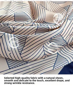 Close-up of soft striped silk scarf with navy geometric lines on warm beige fabric