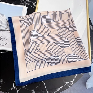 Detailed close-up of a striped geometric square silk scarf with navy blue borders