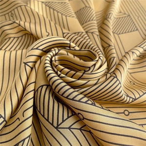 Macro shot of striped silk scarf texture in mustard yellow with black leaf vein patterns