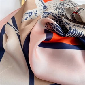 Detail showing smooth satin texture and artistic abstract patterns on colorful silk scarf