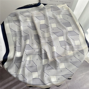 Detail of geometric line pattern on a blue and white square silk scarf on a desk