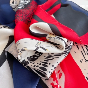 Detail of silk-like scarf featuring red roses and leopard print with glossy texture