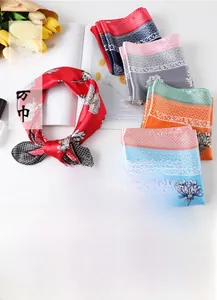 Detail showing various 60x60cm printed silk scarves with floral patterns and hemmed edges
