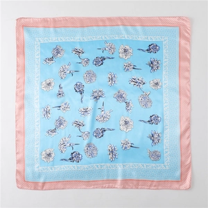 Detail of floral silk scarf showing light blue center and pink geometric pattern borders