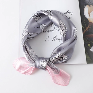 Detail of silk scarf with lotus flower print, pink plaid border and satin texture