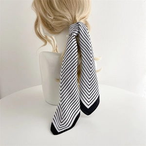 Detail of striped silk scarf tied on a ponytail showcasing a minimalist hair accessory look