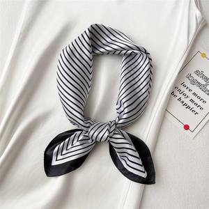 Detail of elegant black and white striped silk square scarf with a smooth satin texture