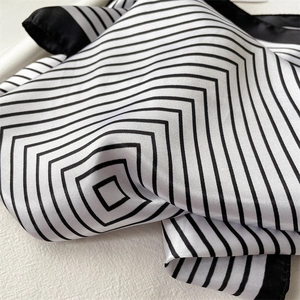 Detailed view of the smooth silk texture and modern black and white geometric pattern