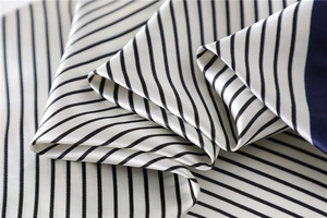 Macro detail of silk striped square scarf showing satin texture and diagonal navy borders