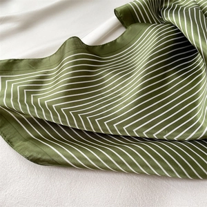 Detailed view of olive green striped silk scarf with elegant satin sheen and hemmed edges