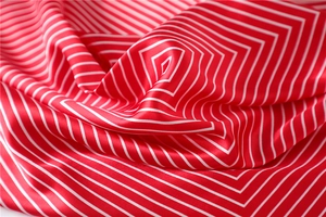 Detailed macro view showing the glossy texture and red-white stripes of the silk scarf