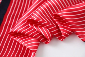 Close-up of red and white striped satin scarf showing elegant silk texture and glossy folds