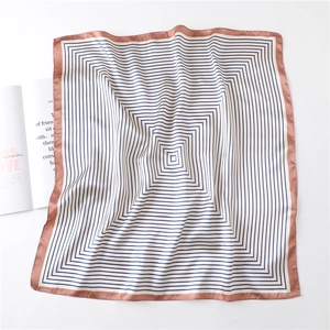 Detailed view of the striped silk square scarf with pink borders and smooth texture