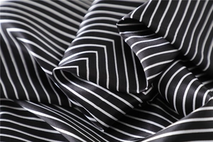 Close-up of black and white striped satin scarf showing silky texture and draped folds