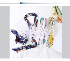 Flat lay of multiple equestrian pattern twilly silk scarves with chain and buckle prints
