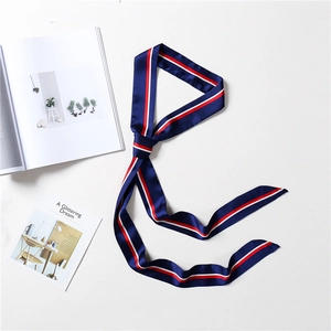 Detail of navy blue striped skinny silk scarf on white background with magazine