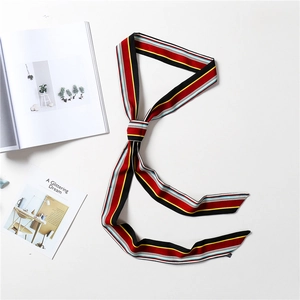 Detail of multi-color striped narrow silk scarf featuring geometric patterns and satin texture