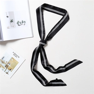 Detail shot of a black narrow silk scarf with white edge stripes on a white background