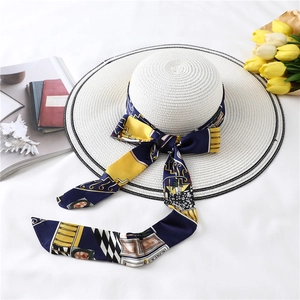 Detail of a wide brim straw hat with geometric silk ribbon and elegant floral decor