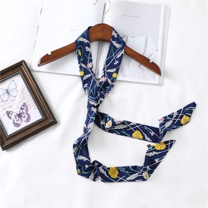 Detail of navy skinny floral scarf tied on a wood hanger with daisy pattern print
