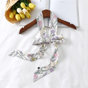 Floral print narrow silk scarf tied in a bow on a wooden hanger with tulip background
