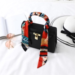 Classic black litchi leather handbag with silk scarf handle and gold hardware detail