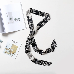 Detail of a black skinny scarf with elephant and floral prints on a white background
