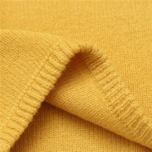 Macro shot of ginger yellow knit fabric with ribbed edge detailing and dense texture