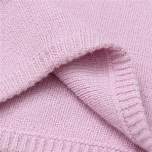 Close-up of light pink knitted fabric texture and ribbed hem detail for winter neck gaiter