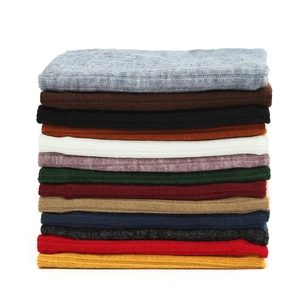 Détail de tours de cou en tricot côtelé épais empilés en plusieurs couleurs