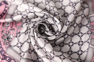 Detailed view of silky satin scarf with elegant chain patterns and smooth pearlescent finish