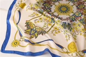 Detailed shot of floral silk scarf featuring baroque patterns and royal blue border