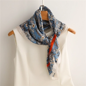Close-up of floral silk scarf with orange hem and Happy New Year text detail