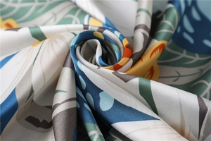 Macro shot of elegant floral silk scarf showing soft texture and vibrant botanical prints