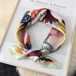 Artistic abstract printed silk scarf displayed on a white art book with soft lighting