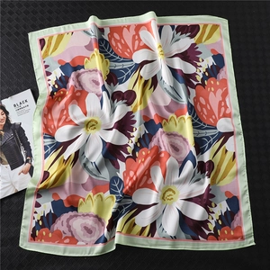 Detailed view of floral pattern silk square scarf with mint green border on black background