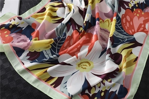 Close-up of floral print silk scarf showing smooth texture and vibrant flower patterns