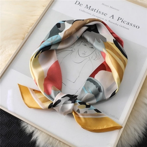 Detailed view of an elegant floral print silk scarf with abstract colorful patterns