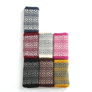 Detail of knitted neck warmers with geometric diamond pattern in seven various colors