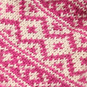 Detailed macro view of pink and beige knit pattern with intricate diamond geometric texture