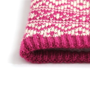 Macro detail of knit snood neck warmer showing pink and beige ribbed wool texture